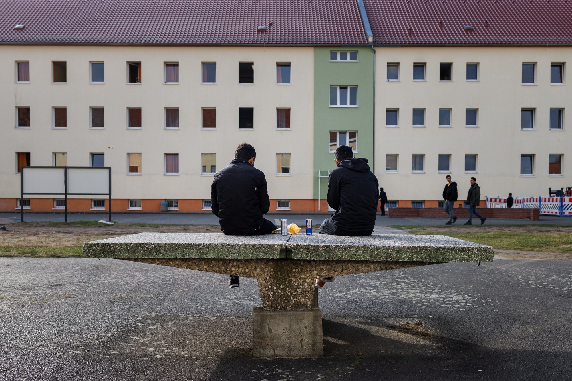 Asylum seekers wait in the courtyard of the Eisenhüttenstadt reception centre, eastern Germany, 2021. Many had crossed the Belarus-Poland border after weeks of violence and deprivation.
